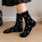 des chaussettes toutes douces noires, grises et blanches au motif d'empreintes de pattes de chat toutes mignonnes