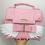 Sac à Main Rose Pâle à Ailes Blanches et Nœud Doré